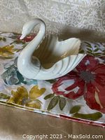 Side view of white porcelain swan dish showing detailed swan head and shell-shaped bowl