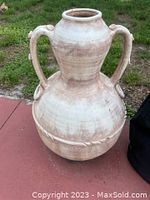 Full front view of large two-handled ceramic vase showing amphora shape and weathered surface.
