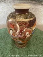 Front view of the vase showcasing detailed hand painted human portraits and decorative patterns in brown, gold, and green hues.