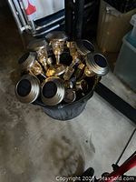 Top view of multiple solar pathway lights with stainless steel tops and embedded solar panels packed in a bucket.