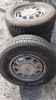 Four 1988 Ford Mustang factory wheels with worn but intact Goodyear tires. Front view shows dirt and dust on wheels and tires.