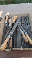 Box of over 25 files and rasps with wooden and metal handles, showing used condition.