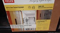 Front of boxed Velux 10-in Sun Tunnel Skylight showing branding, product name and demo hallway light effect graphic