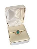 Front view of ring in cream presentation box with lid open