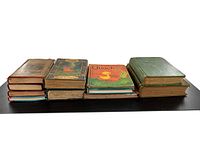 Side view of various closed antique books showing wear consistent with age and different bindings.