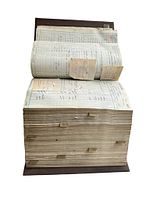 Full view of the antique bound ledger book showing thick pages and a partially open, rolled section with tabbed pages and inserted notes.