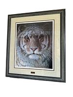 Framed print showing the full tiger face in a black decorative frame with cream matting and small plaque