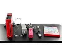 Full lot display showing limited edition red Nintendo Wii console and all accessories: red controller, sensor bar, power adapter, audio-video cable, and Super Mario Bros. Wii game case.