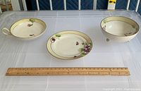 Three-piece Japanese service set shown on a table with a ruler for scale: includes a bowl, plate, and server, all decorated with purple flowers and marked Nippon.