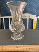Front view of a clear cut lead glass vase with diamond and fan cut patterns, measuring 6.25 inches tall, standing on a flat surface against a blue padded background and a yellow ruler behind for scale.