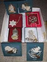 Eight assorted Lenox Christmas ornaments in original boxes, including angels, snowflakes, and teddy bear on sled.