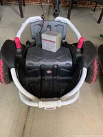 Top-down view of the black and hot pink Power Wheels Wild Thing ride-on cart showing battery pack on seat and front white protective frame.
