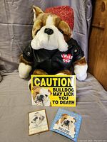 Bulldog plush sitting with two magnets and yellow caution sign placed in front