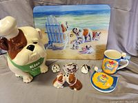 Full view of bulldog kitchen items including cookie jar, salt and pepper shakers, mug with coaster, three magnets, and cutting board in background.