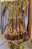 Full view of colorful, patterned long dress with sleeves and elastic waist.