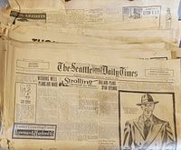 Stack of old newspapers with The Seattle Daily Times visible on top, showing dated headlines and ads from March 1940.