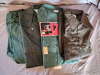 Folded green coveralls and shirt with label showing Big Mac brand and worksuit logo.