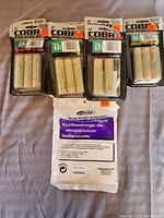 Four packages of Rocket Man Cobra model rocket engines and one packet of Estes recovery wadding displayed on a surface.