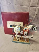 Photo of the painted pony statue in front of its original box, showing full side profile and base details.