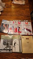Photo showing Danskin dance leotards and several Mondor dance tights in packaging on wooden table