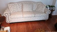 Front view of sofa showing full seating area, rolled arms, and nailhead trim