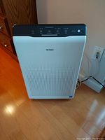 Front view of the purifier showing Winix logo and perforated intake grill