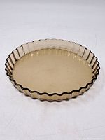 Full view of the vintage Arcopal France glass tart dish with scalloped edges visible, showing overall shape and condition.