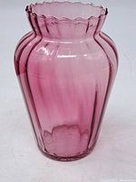 Front side view of vintage pink/purple art glass vase showing ribbed vertical pattern and overall shape.