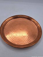 Top view of the round hammered copper tray showing its texture and copper color.