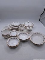 Full set of Queen Anne Fine Bone China including plates, bowls, cups, saucers, sugar bowl, creamer, and covered serving dish arranged on a table