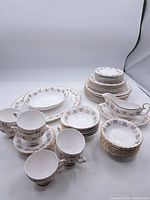 Full view of set including plates, bowls, teacups, saucers, and gravy boat arranged on white background.