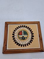 Full view of the framed square sand painting showcasing the indigenous design.