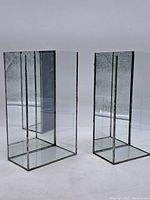 Pair of leaded glass display boxes showing front and side views, clear and textured glass with metal frame