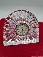Front view of Waterford crystal mantle clock showing clock face with Roman numerals within intricate cut crystal body.