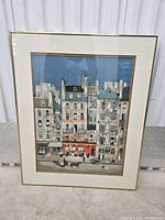 Full view of framed urban Paris scene art showing buildings, pedestrians, horse carriage, and signage.