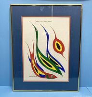 Framed watercolor painting showing abstract fish shapes in multiple colors with blue matting and a thin gold frame.