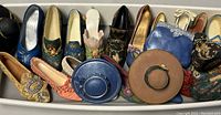 Wide container with various miniature shoes and hats arranged side by side in multiple colors and designs.