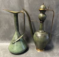 Both pitchers side by side showing shape, patina, and handles. Tallest is 16 inches with dent and minor wear.