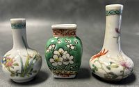 Front view of the three Chinese porcelain miniature vases showing floral hand painted designs and different shapes including round and square bodies
