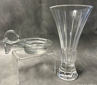 Crystal vase and candleholder displayed side by side on a dark background, showing overall shape and size.