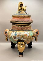 Front view of large Japanese hand painted porcelain koro censer showing detailed artwork, gold accents, and lion-dog finial on the lid.