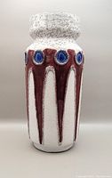 Front view of the West German pottery vase showing the white, reddish-brown, and blue glazed decoration with textured top rim.