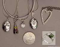 Four sterling silver snake chain necklaces with three 16" and one 18" lengths, pendants including enamelled rocket, cubic zirconia and lockets, a heart-shaped cubic zirconia pendant, and a silver ring with jade stone size 4 beside a Canadian quarter for scale.