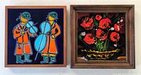 Two framed handcrafted art tiles displayed side by side; left tile depicts two musicians in orange coats and blue instruments on dark background; right tile is floral enamel on copper with red flowers on dark background.