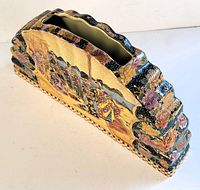 Angled top-down view showing the length, scalloped edge, and handpainted decorations on Satsuma style porcelain vase.