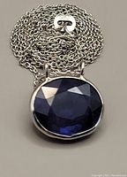 Front view of oval sapphire pendant with coiled chain