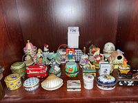 Overview photo of all hinged trinket boxes arranged on a wooden shelf, showing various shapes and sizes.