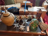 Full view of the lot on glass table showing textured lamp, clear glass stars, green glass ball, dried flowers, and lantern