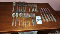 Overall assortment of flatware pieces laid out on wooden table