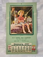 Front view of the 1957 calendar showing detailed image of a boy fishing, a dog, and a man in uniform with company advertisement below.